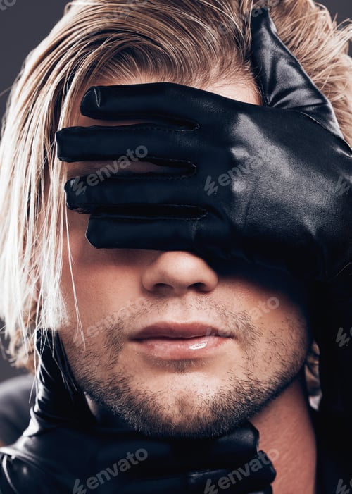Preview: Fashion, beauty and model with leather gloves on his face in a studio with edgy, punk and trendy st