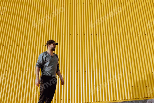 Preview: Man standing near yellow wall
