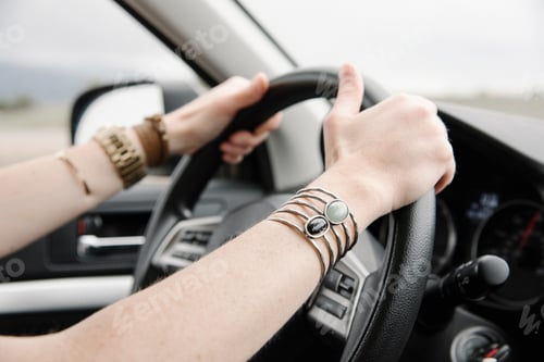 Preview: A woman with her hands on the driver's wheel.