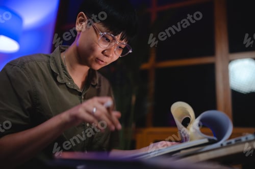 Preview: Late-night freelancer, Dedicated Asian woman working overtime on laptop computer, meeting deadlines