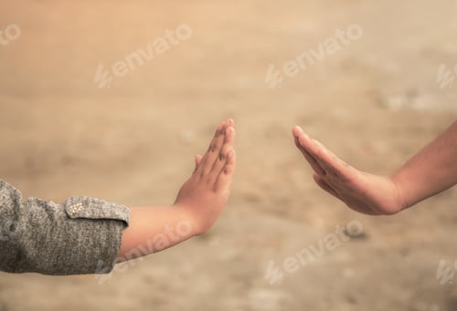 Preview: Selective focus shot of two young children's hands reaching out to touch each other