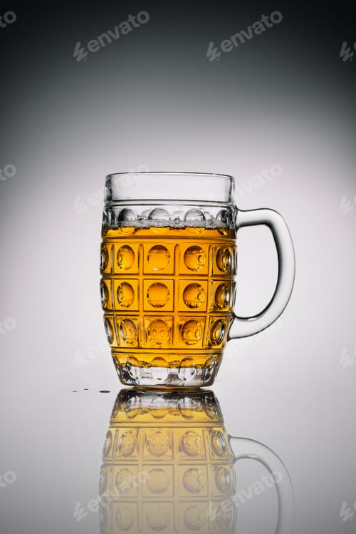 Preview: glass with light cold beer in transparent glass on gray reflecting surface