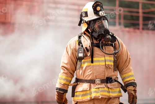 Preview: A firefighter in full protective gear takes a break after exiting a smoke-filled building