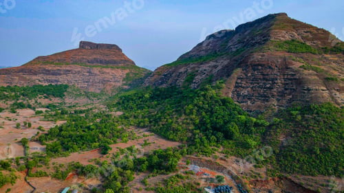 Preview: Beautiful view of the high rocky mountains with green slopes under the blue sky in summer
