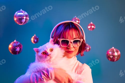Preview: Disco woman with cat listening music with headphones, on studio background