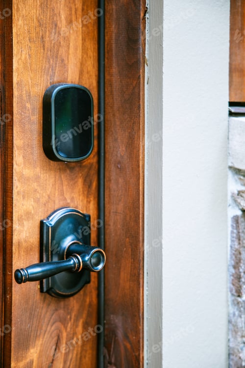Preview: Vertical shot of a black door handle next to fingerprint scanner