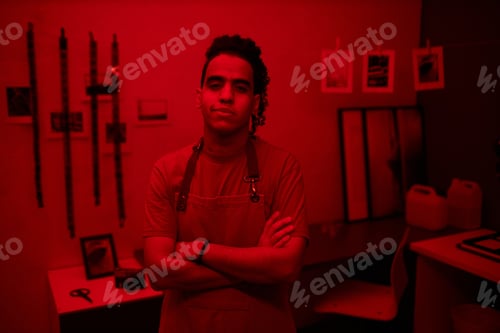 Preview: Young professional photographer standing in darkroom