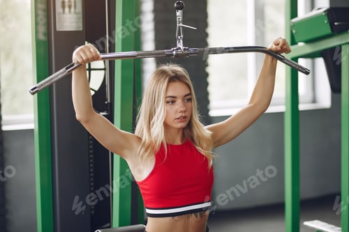 Preview: Sports blonde in a sportswear training in a gym