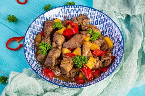 Preview: Delicious fried chicken liver with pepper, apples and herbs on light wooden background