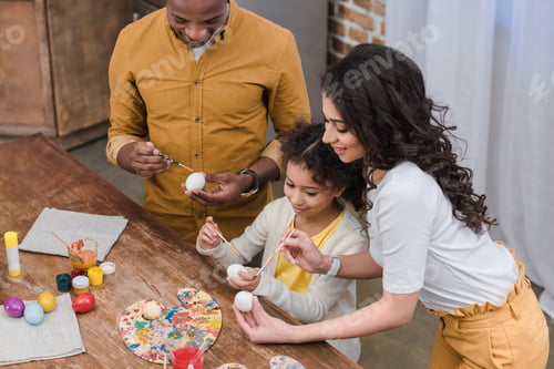 Preview: high angle view of african american family painting easter eggs