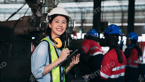 Preview: Industrial worker inspecting and check up machine at factory machines.