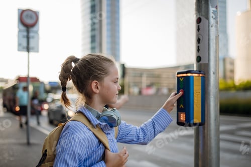 Preview: Schoolgirl standing at the crosswalk and pressing the crosswalk button.