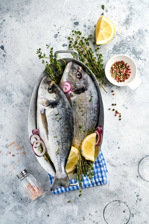 Preview: Raw dorado fresh fish or sea bream with ingredients for making lemon, thyme, garlic, cherry tomato a
