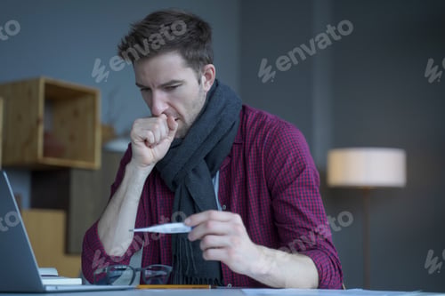 Preview: Unhealthy looking male entrepreneur in scarf around his neck coughing looks at digital thermometer