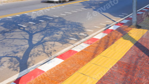 Preview: Yellow tactile paving line on sidewalk with tree shadow on asphalt road surface in urban street