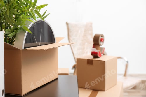 Preview: Moving box with office stuff on table indoors, closeup