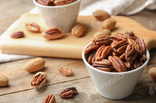 Preview: Tasty pecan nuts in dish served on wooden table. Space for text