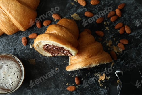 Preview: Concept of tasty breakfast with croissant with chocolate on dark background