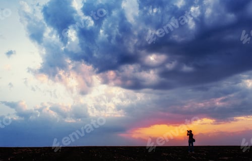 Preview: silhouette of photographer taking photo at sunset