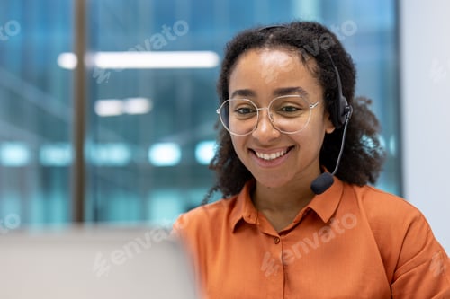 Preview: Smiling woman wearing headset while working remotely in a modern office environment