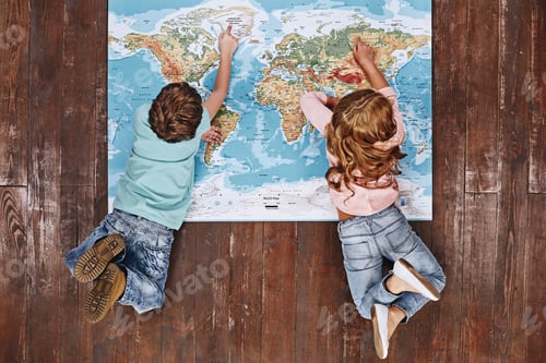 Preview: Discover the World. Children lying on world map, looking at it