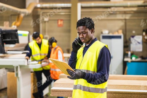 Preview: African american worker making phone call in lumberyard