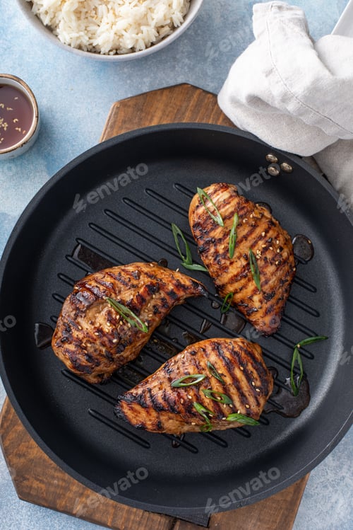 Preview: Grilled teriyaki chicken breast on a grill pan with green onions