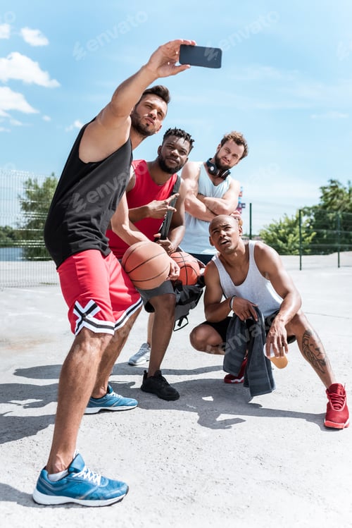 Preview: multicultural team of basketball players taking selfie together