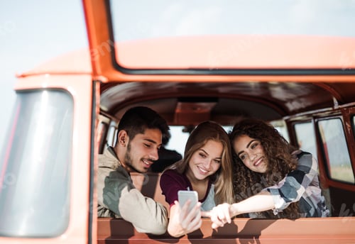 Preview: A group of young friends on a roadtrip through countryside, taking selfie.