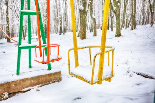 Preview: Empty swing in winter time with snow