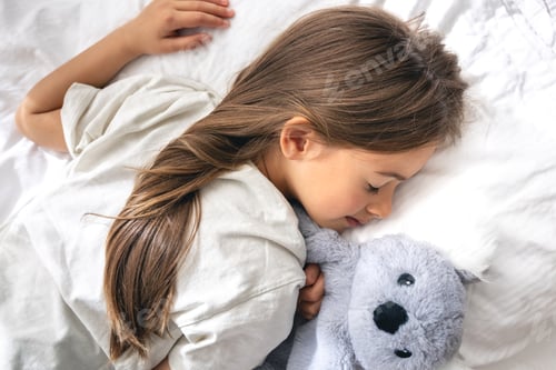 Preview: Cute little girl is sleeping on the bed.