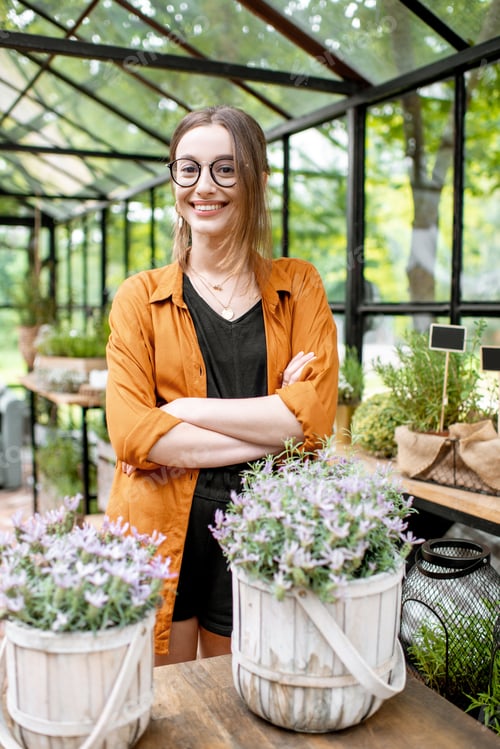 Preview: Woman with herbs and flowers in the greenhouse