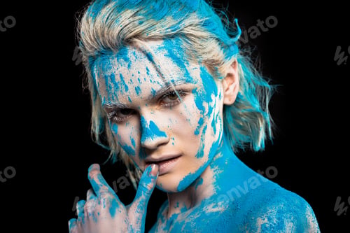 Preview: portrait of passionate girl in blue holi powder, isolated on black