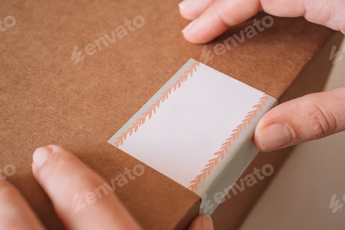 Preview: Cropped photo of female hands packing with scotch tape, parcel for delivery package to buyer. Woman
