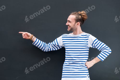 Preview: happy man pointing finger to empty space on black background