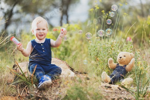Preview: Cheerful boy at bear toy