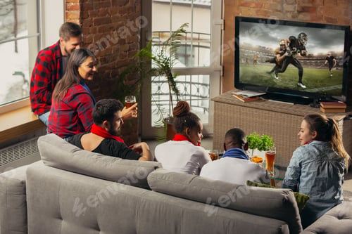 Preview: Excited group of people watching sport match at home