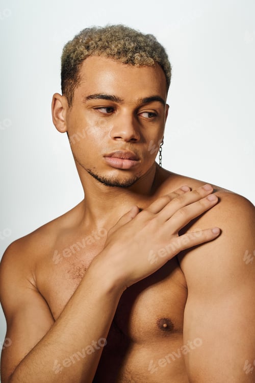 Preview: Young man with dyed hair showcases muscular beauty in a studio setting