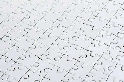 Preview: Close up of a white jigsaw puzzle in assembled state in perspective. Many components o