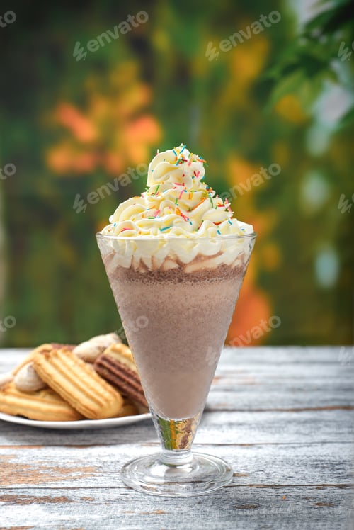 Preview: Chocolate milkshake with whipped cream on a wooden table. Milkshake and sweet cookies