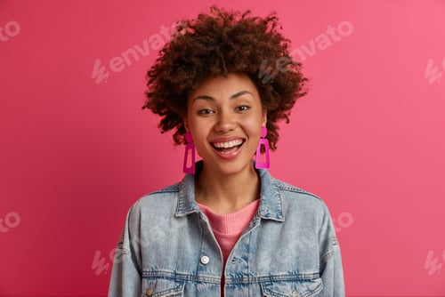 Preview: Portrait of satisfied ethnic woman looks with toothy smile at camera, has happy mood, chuckles over
