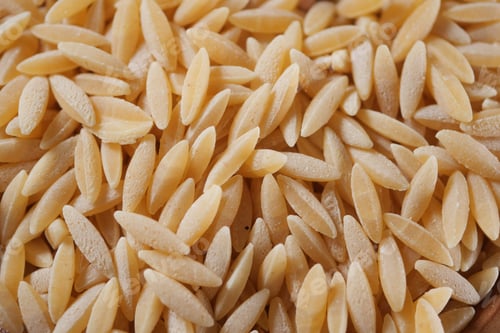 Preview: Orzo pasta on a wooden table in a kitchen setting
