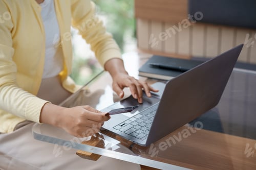 Preview: Close-up of woman using laptop and credit card for online shopping. Online payment.