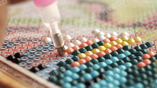 Preview: Diamond painting with pen closeup. art therapy concept. Laying out a diamond mosaic improves a woman