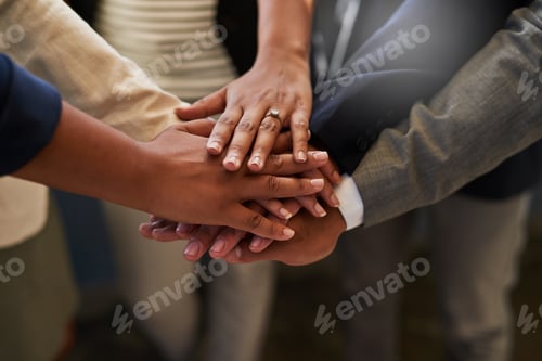 Preview: Closeup shot of a group of unrecognizable businesspeople joining their hands together in a huddle