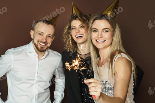 Visualização: Pessoas felizes usando chapéus de festa com brilhos ardentes durante o feriado ou a celebração do evento