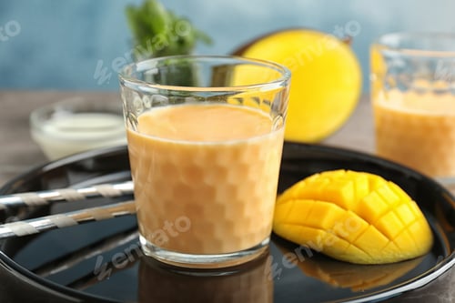 Preview: Glass with healthy detox smoothie and mango on tray