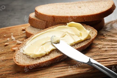 Preview: Spreading butter onto toast with knife on wooden board