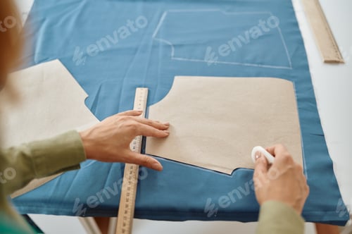 Preview: Dressmaker measures cloth on the table in workshop