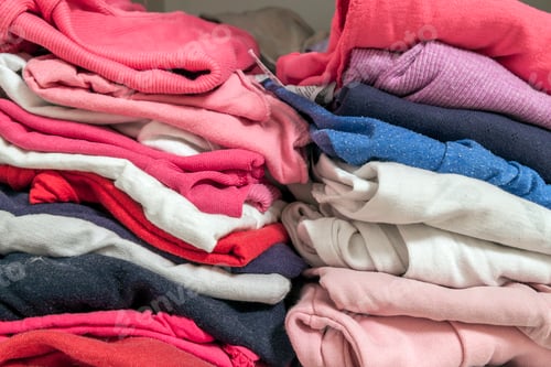 Preview: A stack of knitted warm woolen clothes in wardrobe close up
